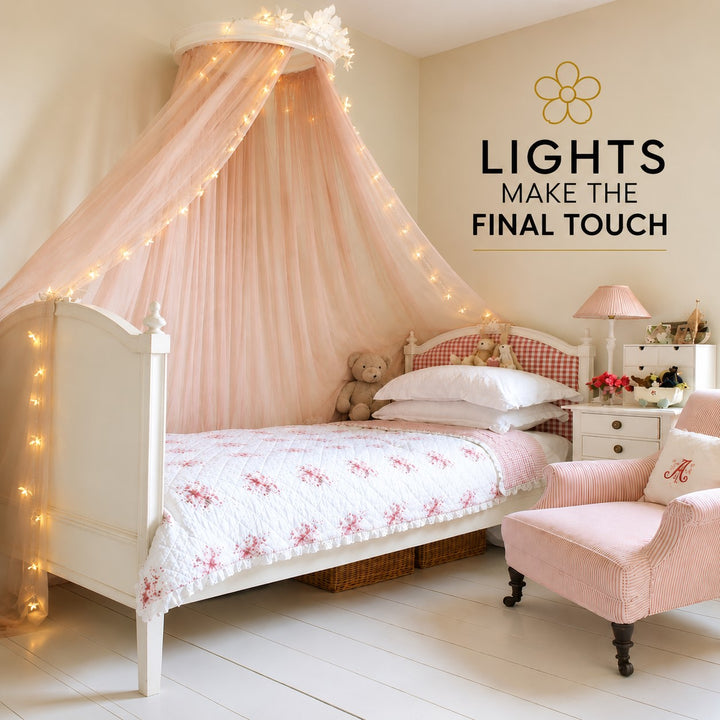 A styled children's bedroom featuring a white single bed with a pink canopy draped with fairy lights, a pink armchair, and a bedside table with a lamp. Text on the wall reads 'LIGHTS MAKE THE FINAL TOUCH'.